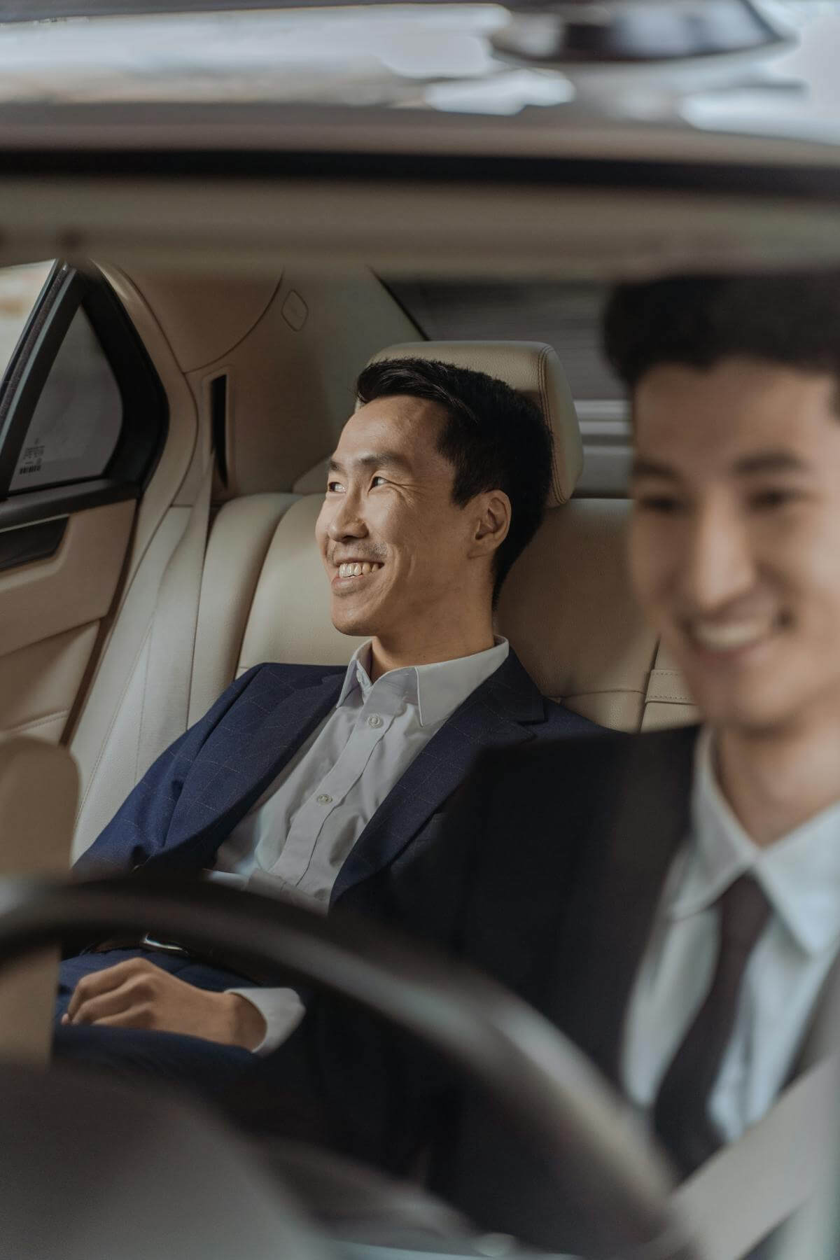 Passengers being driven in the back seat of a car, relaxed