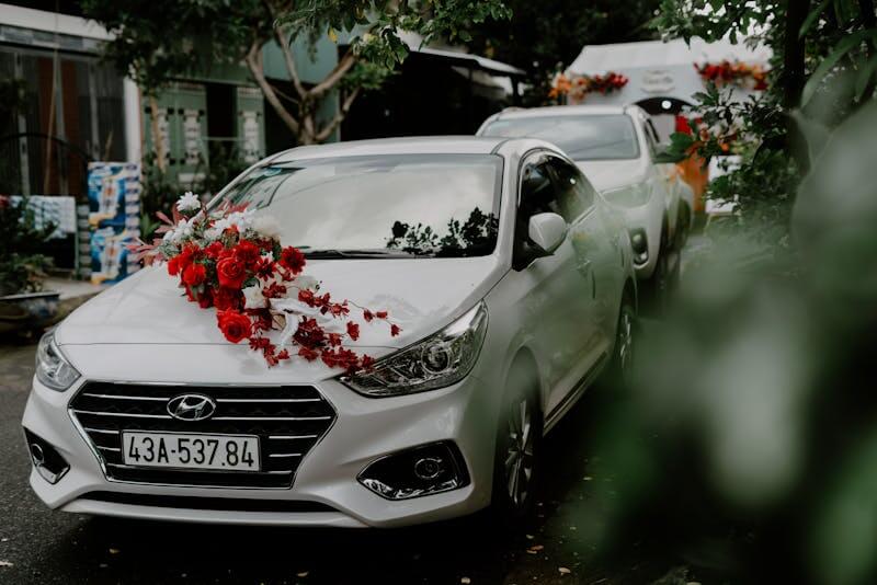 White Hyundai wedding car decorated with red flowers